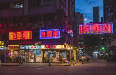 Hong Kong şehir merkezindeki binalar ve iş yerleri boyunca renkli neon reklamlar. Fotoğraf akşamleyin çekildi.
