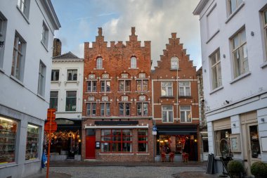 Brugge Belçika şehir merkezi boyunca geleneksel ortaçağ tarzı binalar. Fotoğraf, Flanders 'ta bulutlu bir günde çekildi.