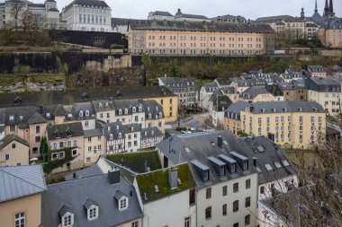 Lüksemburg 'un Avrupa şehrinin duvarları boyunca uzanan eski ortaçağ kasabasındaki renkli, pembe, sarı ve gri binalar.