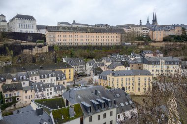 Lüksemburg 'un Avrupa şehrinin duvarları boyunca uzanan eski ortaçağ kasabasındaki renkli, pembe, sarı ve gri binalar.