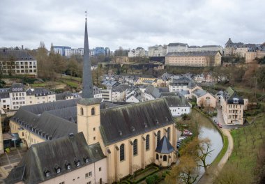 Kilise katedrali ve renkli pembe, sarı ve gri binalar eski kasaba köyünün bahçesinde duvarlı bir uçurum ve Lüksemburg 'un eski köprüsü boyunca