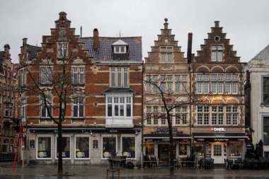 Gent şehir merkezindeki Vrijdagmarkt boyunca kurulmuş güzel geleneksel mimari binalar. Fotoğraf, Flanders 'ta bulutlu bir günde çekildi.