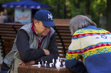 Krakow, Polonya - Temmuz 13: yaşlı adamlar bir parkta satranç üzerinde 13 Temmuz 2016 Krakow, Polonya için oynuyorsun