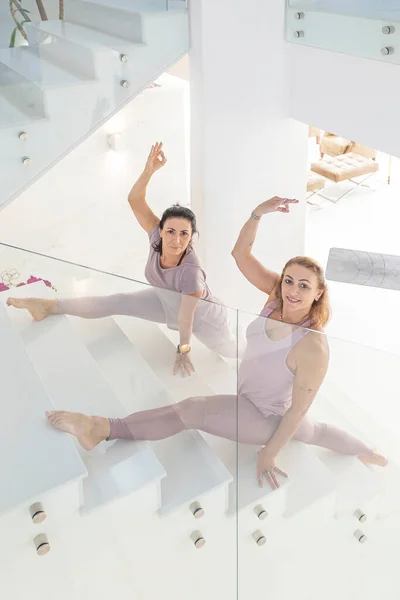 Duas Mulheres Praticando Ioga Nas Escadas Uma Casa Ambiente Minimalista Imagem De Stock