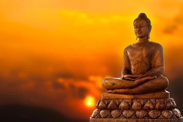 Buddha och solnedgång Stockbild