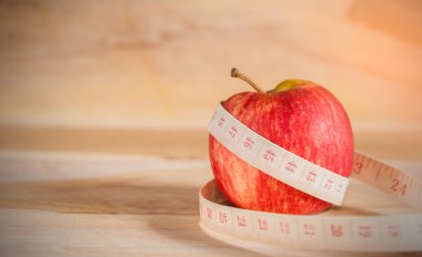 Kırmızı elma ve ahşap zemin üzerinde şerit metre