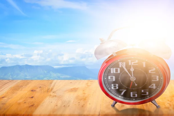 Reloj rojo tiempo sobre madera y fondo azul cielo —  Fotos de Stock