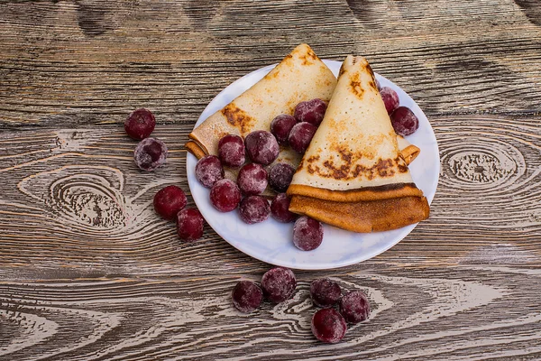 Pfannkuchen mit Kirschen auf Teller auf Holztisch — Stockfoto