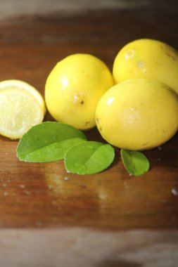 taze ve sağlıklı limon ve dilimlenmiş limon ahşap arka planda