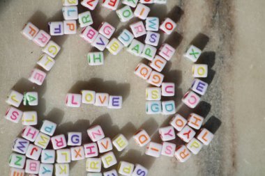 Beyaz arka plandaki renkli harflerden oluşan renkli bir kelime. Sevgililer Günü 'nün 