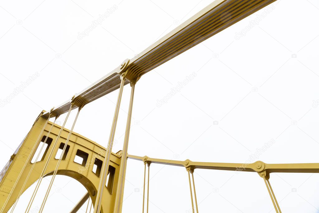Yellow painted bridge upright and suspension supports, horizontal aspect