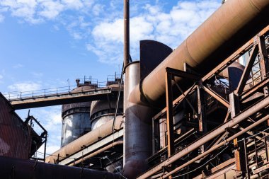 Eski bir çelik fabrikasını, labirentleri, fırınları, mavi gökyüzünü, yatay görünümü...