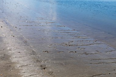 Kumlu deniz kenarları ve durgun mavi sular, okyanus körfezi veya nehir, yatay görünüm