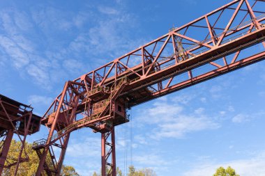 Büyük bir tramvay yapısı, paslanmış metal endüstriyel mimarisi mavi gökyüzüne karşı, yatay görünüm