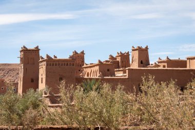 Fas 'ın Ait Benhaddou Çarı' nda geleneksel toprak mimarisi. Ait Benhaddou antik güçlendirilmiş köyünde tarihi çamur tuğla kuleler ve palmiye ağaçları.