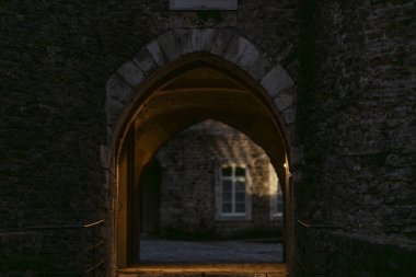 Fransa 'nın eski Boulogne-sur-Mer kasabasında sıcak akşam ışığı ile aydınlatılan tarihi taş kemer yolu. Boulogne-sur-Mers tarihi merkezinde dokulu taş duvarlı ortaçağ geçidi. 
