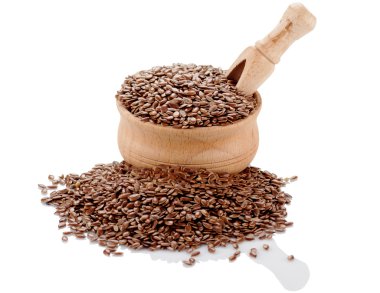 Beyaz zemin üzerinde bir kürek ile ahşap bir kabın içinde keten tohumu.