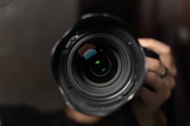 Yumuşak yansımaları ve bulanık bir arkaplanı olan profesyonel bir kamera merceğinin yakın çekimi. Görüntü, fotoğraf, optik ve yaratıcı ekipmanları ön plana çıkarıyor. Yüksek kalite fotoğraf