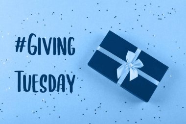 Açık mavi arka planda parıltıları olan mavi bir hediye kutusu. Noel, doğum günü, tatil konsepti. Üst görünüm, düz görünüm, kopyalama alanı