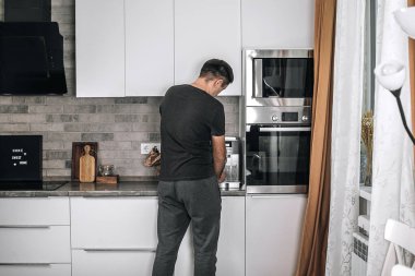 Evde kahve hazırlama konsepti. Adam sabah kahvesini hazırlıyor. Yaşam tarzı, ev hayatı konsepti.