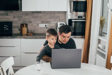 Evden çalışıp bebeğe bakmakla meşgul bir iş adamı.