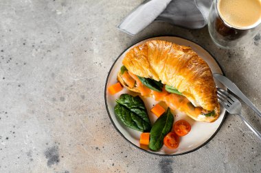 Süzme peynirli kruvasan sandviç, somon balığı, ıspanak. Sağlıklı kahvaltı. Üst görünüm, alanı kopyala