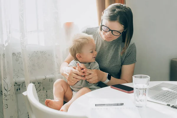 妈妈想在家里用笔记本电脑工作 花时间和男婴一起照看孩子 工作妈妈的概念 — 图库照片