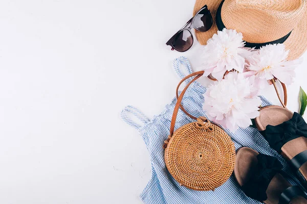 Weibliche Sommeraccessoires Kleid Rattanbeutel Strohhut Schwarze Sandalen Pfingstrosenblumen Auf Weißem — Stockfoto