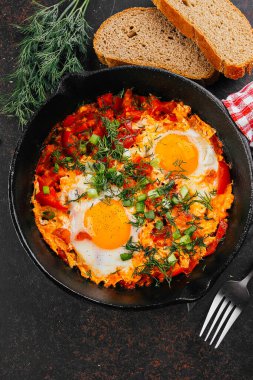 Ekmekli Shakuka 'nın en iyi manzarası. Yumurtalı, domatesli ve demir tavada dereotlu tabak. Kahvaltıda Keto yemek diyeti.