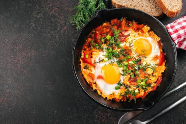 Kahvaltı konsepti. Yumurtalı Shakshuka, domates ve demir tavada dereotu. Üst görünüm, alanı kopyala.