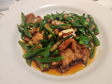 Taze domuz eti ve tabakta yeşil biber var.