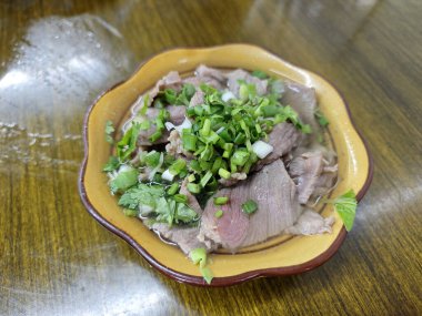 Kaynamış et dilimi ve yeşil soğan.