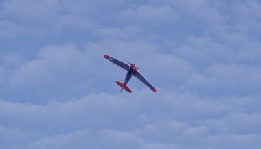 Tek motorlu, pervaneyle çalışan, 2. Dünya Savaşı tarzı bir uçak gökyüzünde dönüyor.