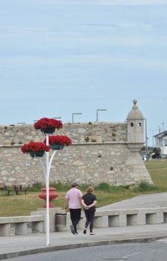 İnsanlar bir bahar sabahı Portekiz 'in kuzeyindeki Vila Praia de Ancora kasabasında yürüyorlar.