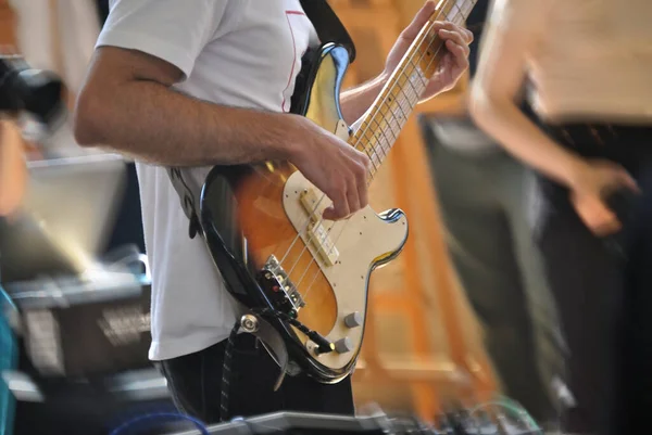 Bir şehirde halka açık bir yerde bas gitarla müzik çalan bir kişi, canlı bir sanat ve eğlence anı