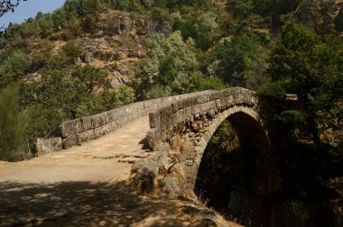 Ortaçağ ve tarihi bir köprü bir dağ yolunda, kayadan yapılmış kemer ve Roma mimarisi ile.