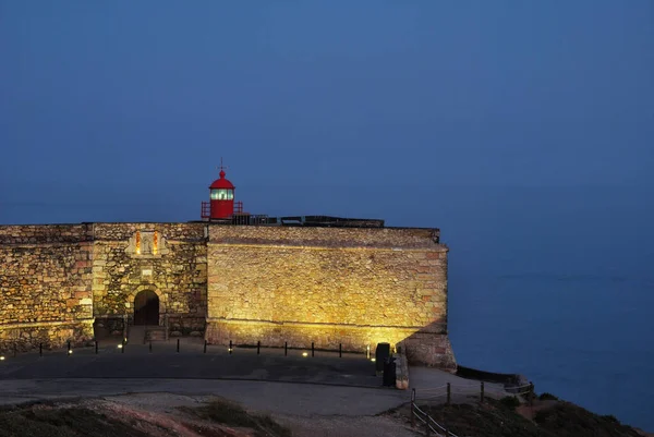 Sao Miguel Arcanjo Kalesi şafakta deniz feneri ile Nazare, Portekiz, deniz ve ışıklar açık