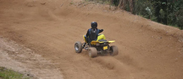 Çamur zeminde dört tekerli bisiklet süren, yanlama eğrisi çizen, zemini yükselten biri.
