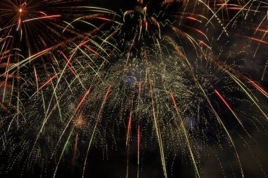 Gökyüzünde küçük havai fişek patlamaları, yeşil ve kırmızı renkler, basit arkaplan