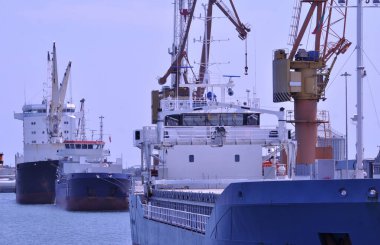 Kargo gemileri konteynır ve malları yüklemek ve boşaltmak için bir limanda durdu.