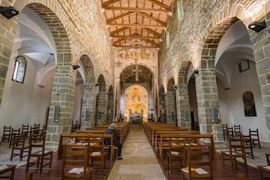 Corno di Rosazzo, İtalya - Mayıs 2021: Abbazia di Rosazzo (Rosazzo Abbey) 'deki San Pietro Kilisesi' nin geniş açılı iç manzarası. Fotoğrafta Romen taş kemerleri, kereste kirişli tavan ve sunağın üzerinde antik freskler sergileniyor. Bir soli.