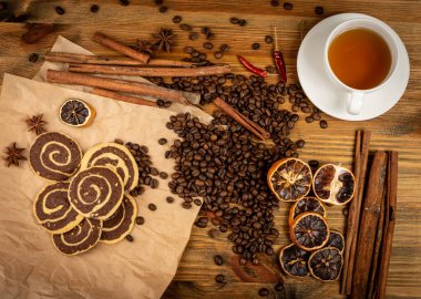 Baharatlı tarçınlı kurabiye çikolatalı, kahveli ve fındıklı ahşap arka plan manzaralı. Kahverengi ve beyaz yuvarlak yumuşak bisküviler, zencefilli pekmez kurabiyeleri, Noel kurabiyeleri