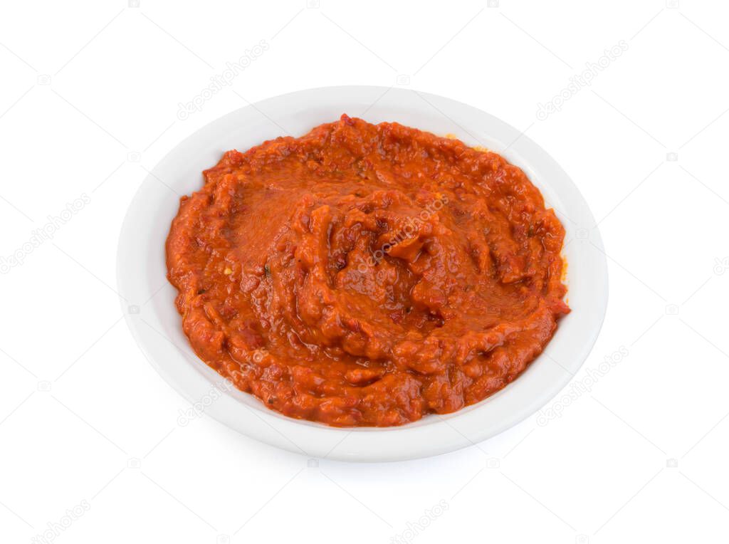 Ajvar or pindjur orange vegetable spread made from bell peppers, eggplants and oil. Marinara sauce, salsa, chutney or lutenica in white bowl isolated