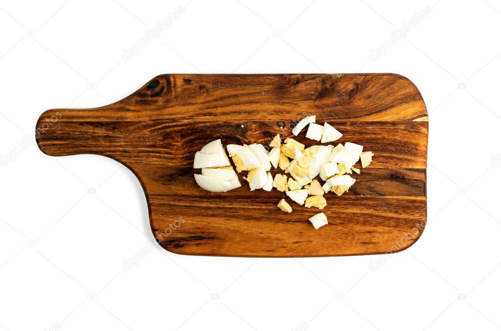 Diced Cooked Egg on Wooden Cutting Board Isolated on White Background. Chopped Boiled Eggs Top View