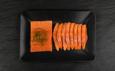 Black Background Top View 'da çiğ somon filetosu dilimleri. Taze Kırmızı Balık Kalın Parçaları ya da Kopya Alanı Olan Alabalık