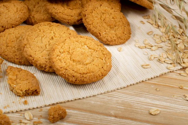 Thin oatmeal cookies or healthy cereal oat crackers closeup. Crispy anzac biscuit cookie with oat flakes on rustic table background