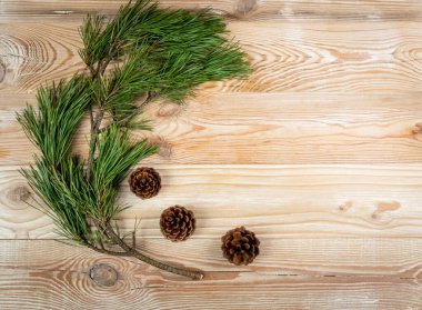 Ahşap masa manzaralı çam dalları olan bir Noel arkaplanı. Kopya uzayı olan kozalaklı çerçeve. Yılbaşı tebrik kartı için Noel ağacı dalları sınırı