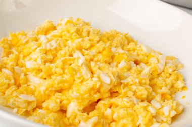 Çırpılmış yumurtanın makro fotoğrafı, izole edilmiş omlet. Kahvaltı yumurtaları tuzlu ve tereyağlı çırpılmış ya da karıştırılmış. Sabah sıcak omlet, taze omlet manzaralı.