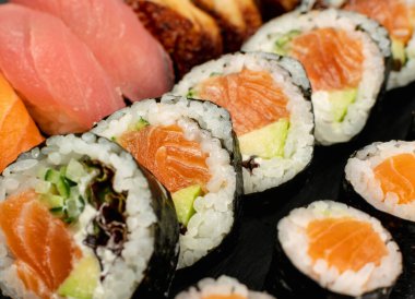 Çeşitli Japon Suşi Yemekleri 'nin büyük seti. Nigiri ve Nori Maki Suşi Rolls with Raw Somon, Maguro Tuna, Unagi Yılanbalığı, Avocado, Salatalık, Yeşil Salata ve Philadelphia Peyniri