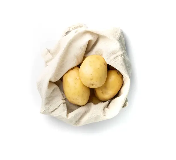 白い背景の上面に隔離された生のジャガイモの山全体 エコバッグの中の黄色洗浄バイオジャガイモ — ストック写真